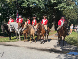 Men on horseback dressed in British costumes