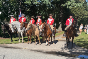 Men on horseback dressed in British costumes